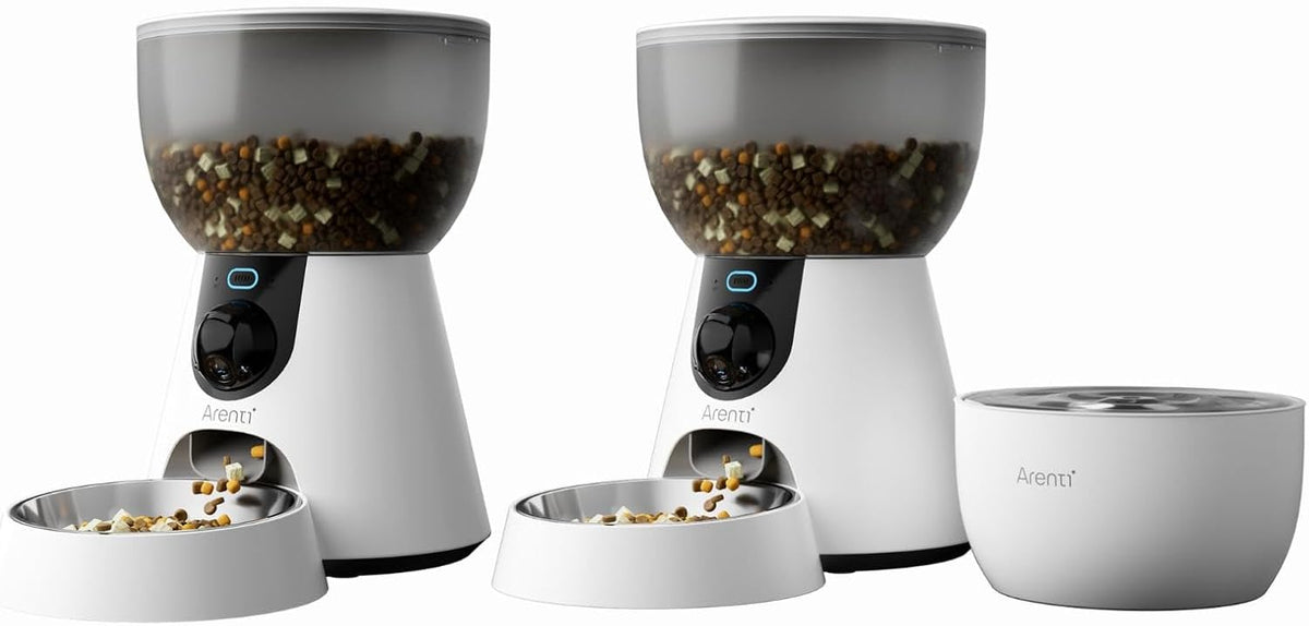 Two automatic camera cat feeders and a water fountain set up side by side