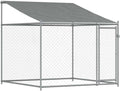 Gray galvanized steel dog cage with roof and door in a garden