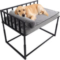 Elevated metal bedside dog bed with mat beside a human bed