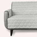 Light gray quilted cotton pet couch cover on a three-seat sofa