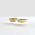 Clear acrylic raised feeder holding two gold stainless steel dog bowls