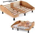 Raised wooden dog bed frame holding a cushioned pet mattress
