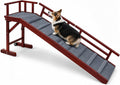 White wooden dog ramp with side rails, wheels and top platform beside a bed