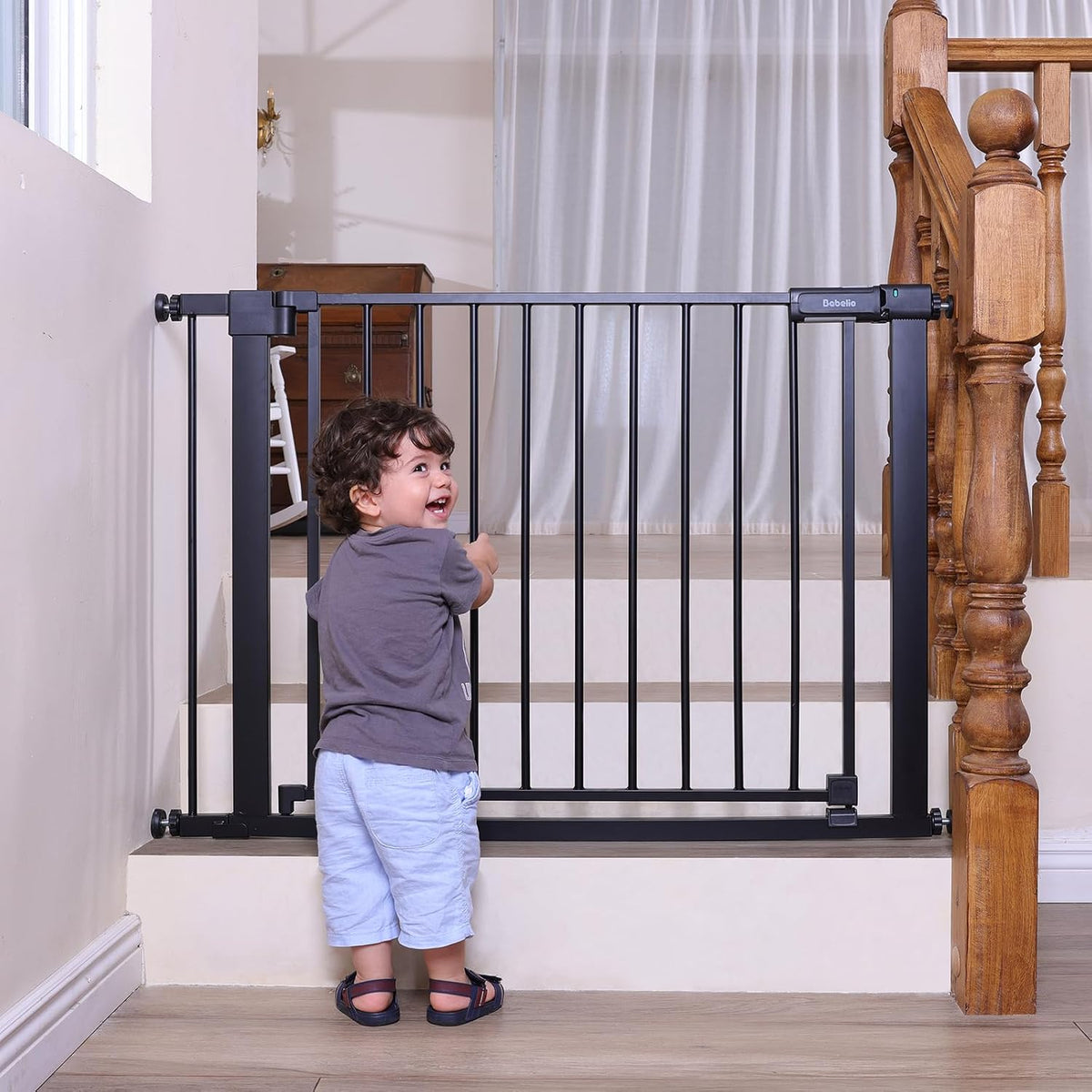 Black pressure mounted dog gate with walk-through door in a doorway