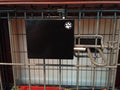 Automatic crate door opener mounted on a wire dog crate with remote control