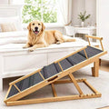 Adjustable wooden dog ramp set against the side of a bed