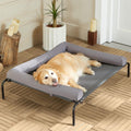 Grey raised mesh dog cot with sloped headrest outdoors