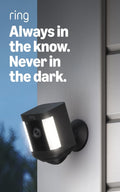 Black wireless home security camera with motion LED lights mounted outdoors