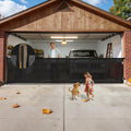 Black retractable mesh dog gate stretched across a wide indoor opening