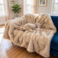 White faux fur dog throw with brown tips on a bed