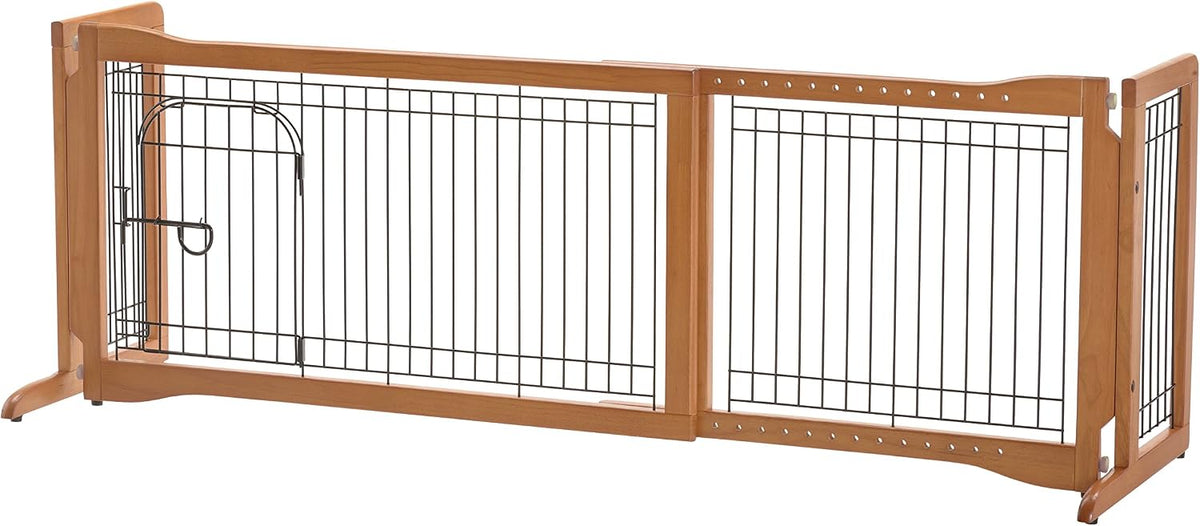 Freestanding wire pet gate with side panels and small walk-through door in a hallway