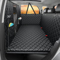 Black hard bottom dog back seat extender with high mesh barrier in a car rear seat
