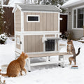Grey two-story wooden outdoor cat house with escape doors