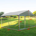 Metal outdoor dog kennel with waterproof top cover in a backyard