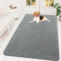 Large grey chenille rug in an entryway with a dog standing on it