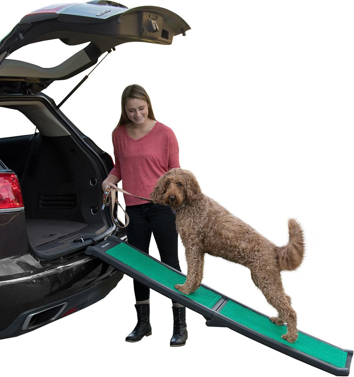 Black and green portable dog ramp with high-traction surface leaning against a car