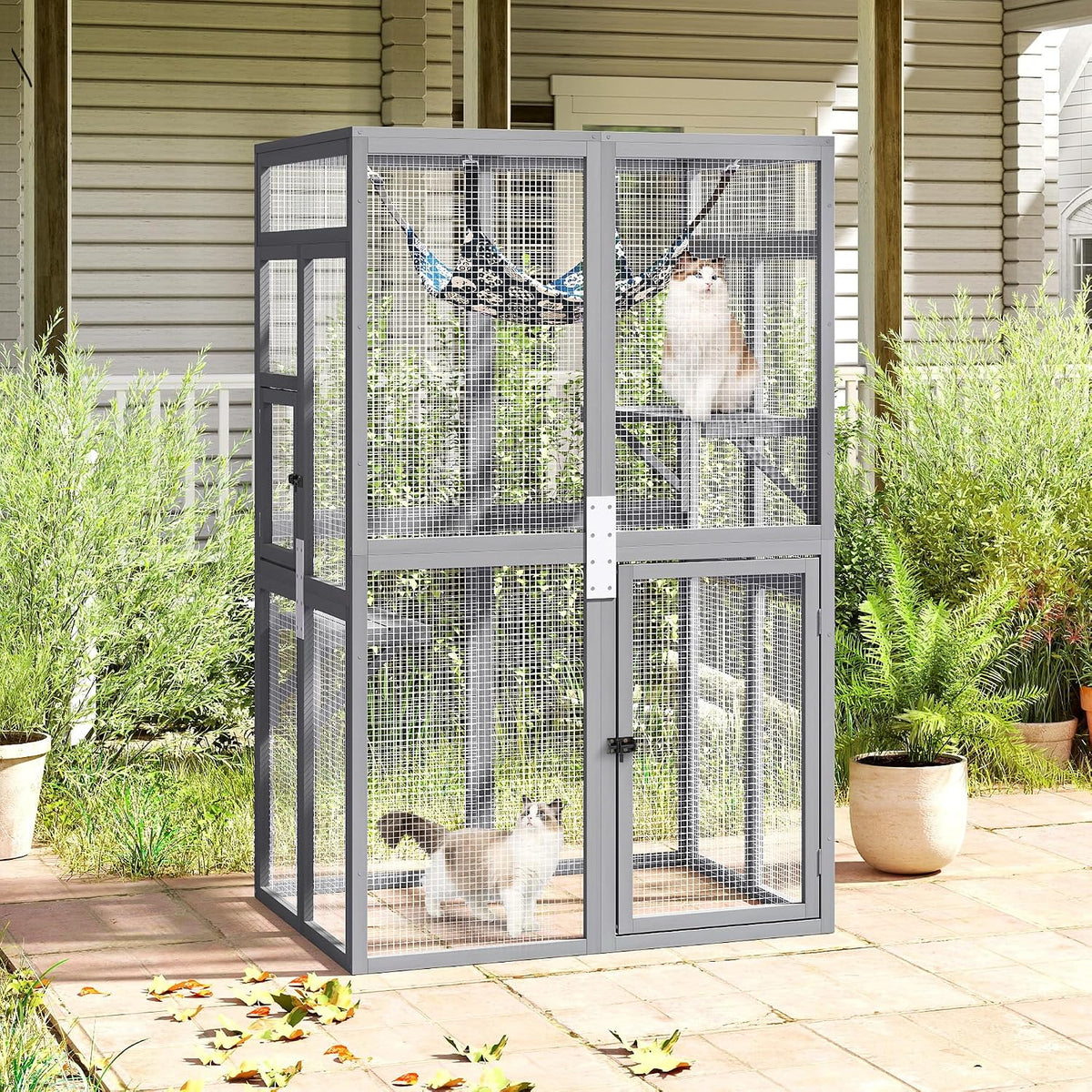 Gray wooden outdoor catio enclosure with mesh walls, platforms and hammock