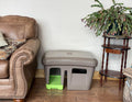 Covered cat litter box with paw-cleaning grid exit and viewing windows